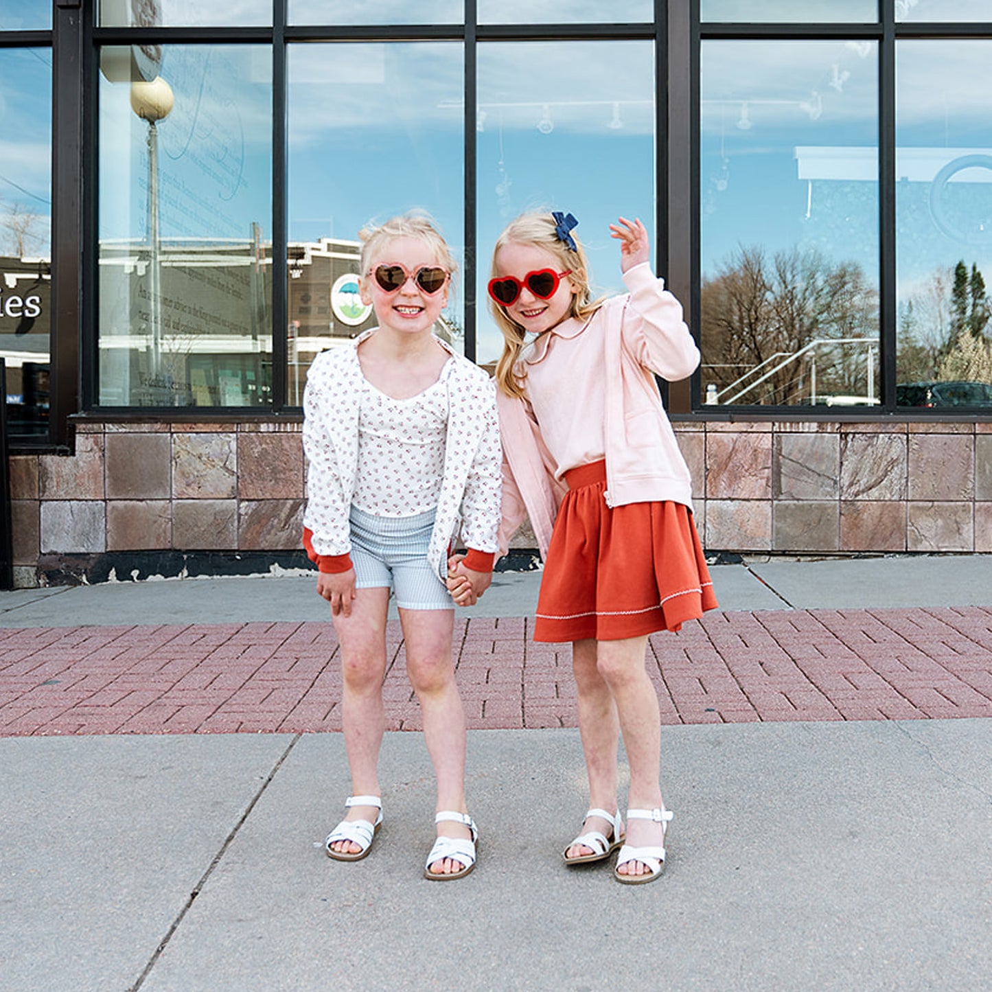 two little girls standing on sidewalk wearing high quality ethically produced organic pima cotton kids clothing styles.